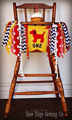 a wooden chair with a one year old banner on it