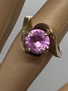 a close up view of a ring with a pink stone