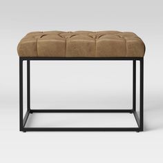 a brown bench with black legs and a tan upholstered cushion on the top