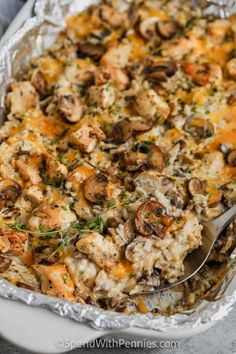 chicken and mushroom casserole in a white dish with a serving utensil