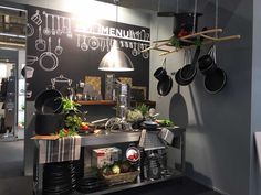 a kitchen area with pots and pans hanging from the ceiling, along with other items