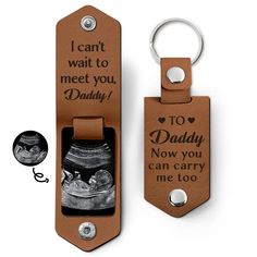 a brown leather keychain with an image of a shoe in it and the words, i can't wait to meet you daddy now you can carry me too