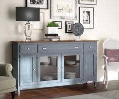 a blue buffet table with glass doors and pictures on the wall