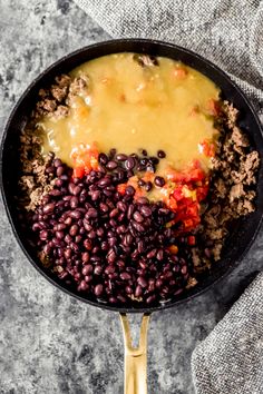 a skillet filled with beans, meat and cheese