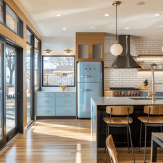 a kitchen with wooden floors and blue cabinets, along with an island in the middle