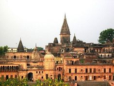 an old building with many spires in the middle of it and trees on the other side