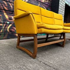 two yellow chairs sitting next to each other in front of a building