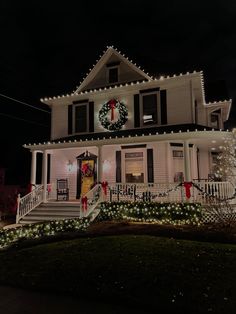 a white house with christmas lights on the front porch