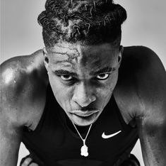 a black and white photo of a man with dreadlocks looking at the camera