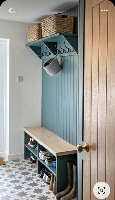 an entryway with blue painted walls and wooden shelves filled with shoes, buckets and baskets