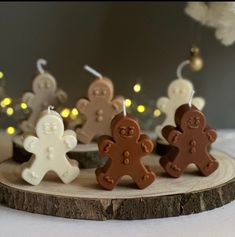 some small brown and white gingerbreads are on a wooden board with lights in the background