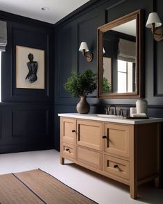 a bathroom with dark blue walls and white flooring has a large mirror above the sink