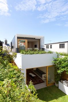 an aerial view of a house with plants growing on the roof and balcony area above