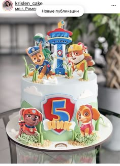 a birthday cake decorated with the characters of paw patrol on it's top tier