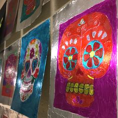 colorful paper cut sugar skulls hanging on a wall