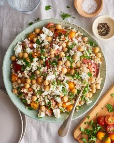 a salad with chickpeas, tomatoes, and feta cheese on a plate