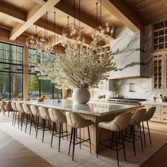 a large dining room table with chairs and a vase filled with flowers on top of it