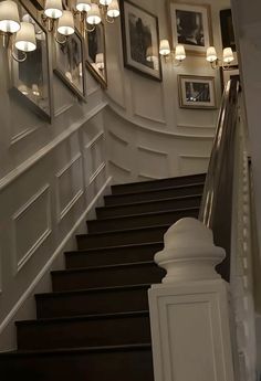 the stairs are lined with framed pictures and lights