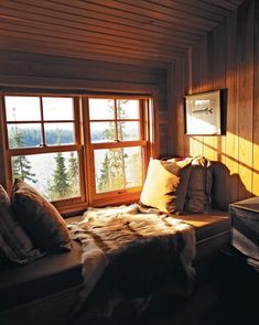 a bed sitting next to a window in a bedroom on top of a wooden floor