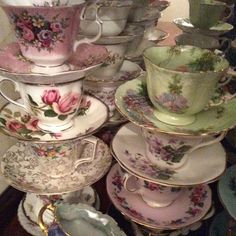 a pile of tea cups and saucers sitting next to each other