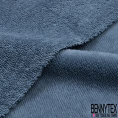 a close up shot of the texture of a blue towel with text that reads benny tex