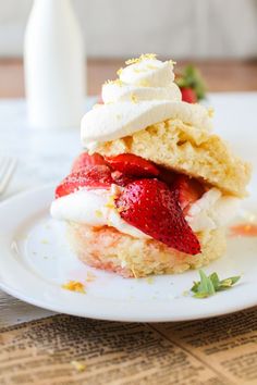 a piece of cake with strawberries and whipped cream on top