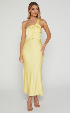 a woman wearing a yellow dress with one shoulder draped over the top and an asymmetric