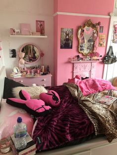 a bedroom with pink walls and lots of stuff on the bed