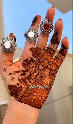 a woman's hand with three rings on it and the words binddush written in arabic