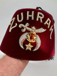 1940'S Zuhrah Shriners Fez Hat with unusual Aurora Borealis Rhinestone Lettering.. Traditional logo with Egyptian images, long black tassel, with a rhinestone pin attached to keep in place. Vented top, and a leather sweatband that is in perfect condition. This is all quality wool felt. This is in EXCELLENT VINTAGE CONDITION. The wool felt looks great. The tassel is in beautiful condition without any tangles.. and has a rhinestone pin attached to it to keep it in place. The lettering is in aurora borealis rhinestones that reflect light in different colors. Appliques, lettering and the label inside Fez are in Very Good Vintage Condition The size is marked on the felt inside the fez as a  7-1/8 Inside measure: 22-3/4 Inches Zuhrah Shriners is a fraternity based on fun, fellowship and philanth Fez Hat, Traditional Logo, Midwest Region, Costume Hats, Long Black, Aurora Borealis, Minneapolis, Costume Accessories, Wool Felt