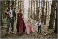 a family walking through the woods holding hands