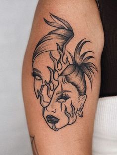 a woman's face with flames coming out of her eyes tattoo on the arm