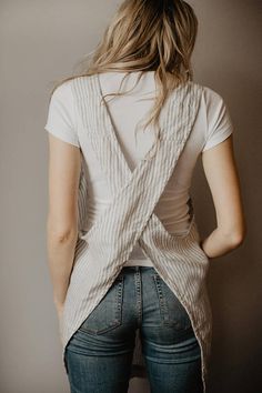 the back of a woman wearing jeans and a white shirt