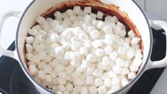 a pot filled with marshmallows on top of a stove