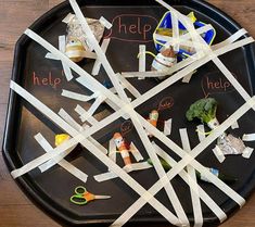 a black tray topped with lots of different types of food and writing on paper strips