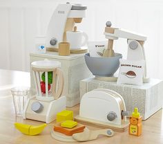 an assortment of kitchen appliances sitting on top of a wooden table