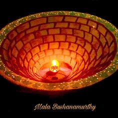 a lit candle in a bowl on a table