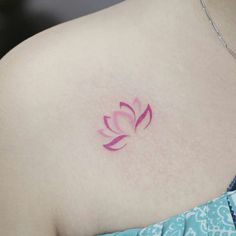 a woman's breast with a pink flower tattoo on it