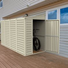 an empty storage shed on a deck with a bicycle parked in the door and windows