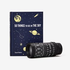 a book with an image of the planets and stars on it, next to a telescope lens