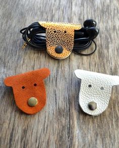 three animal shaped hair clips sitting on top of a wooden table