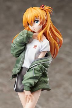 a doll with orange hair is posed on a white surface and wearing a green jacket