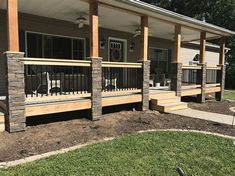 the front porch is made out of wood and has stone steps leading up to it