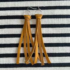 two leather tassels are hanging on a black and white striped cloth