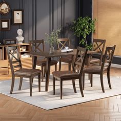 a dining room table with six chairs and a potted plant in the corner next to it