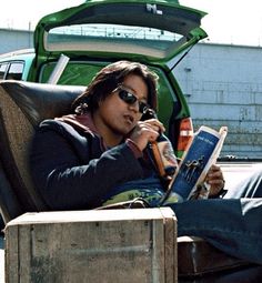 a woman sitting in a chair reading a book