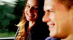 a man and woman are smiling while riding in a car