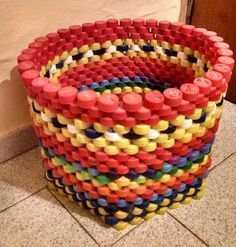 a basket made out of plastic cups sitting on the floor