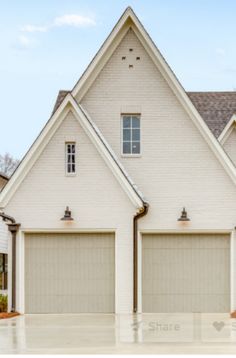 a white house with two garage doors and windows