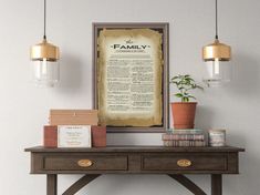 a wooden table topped with books under two hanging light fixtures next to a wall mounted poster